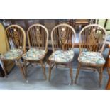 A SET OF FOUR HARDWOOD HOOP BACK DINING CHAIRS, WITH WHEEL SPLATS, PANEL SEATS WITH SQUAB CUSHIONS