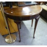 A MAHOGANY DEMI-LUNE FLAP TOP CARD TABLE, ON SEMI-CABRIOLE LEGS