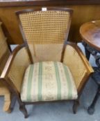 AN OAK FRAMED ARMCHAIR, HAVING CANE BACK AND SIDES ON SHAPED FRONT LEGS, 87cm high, seat 46cm wide