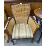 AN OAK FRAMED ARMCHAIR, HAVING CANE BACK AND SIDES ON SHAPED FRONT LEGS, 87cm high, seat 46cm wide