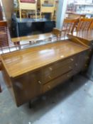 WRIGHTON 1960S TEAK DRESSING TABLE WITH FRAMELESS MIRROR, THREE CENTRE DRAWERS AND END CUPBOARDS, ON