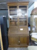 MEDIUM OAK BUREAU BOOKCASE, THE UPPER PORTION ENCLOSED BY TWO GLAZED DOORS, THE BUREAU WITH