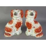 A PAIR OF WELL-MODELLED LATE NINETEENTH CENTURY STAFFORDSHIRE POTTERY MANTEL DOGS, painted with iron