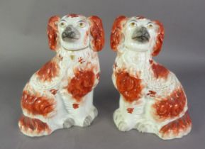 A PAIR OF WELL-MODELLED LATE NINETEENTH CENTURY STAFFORDSHIRE POTTERY MANTEL DOGS, painted with iron