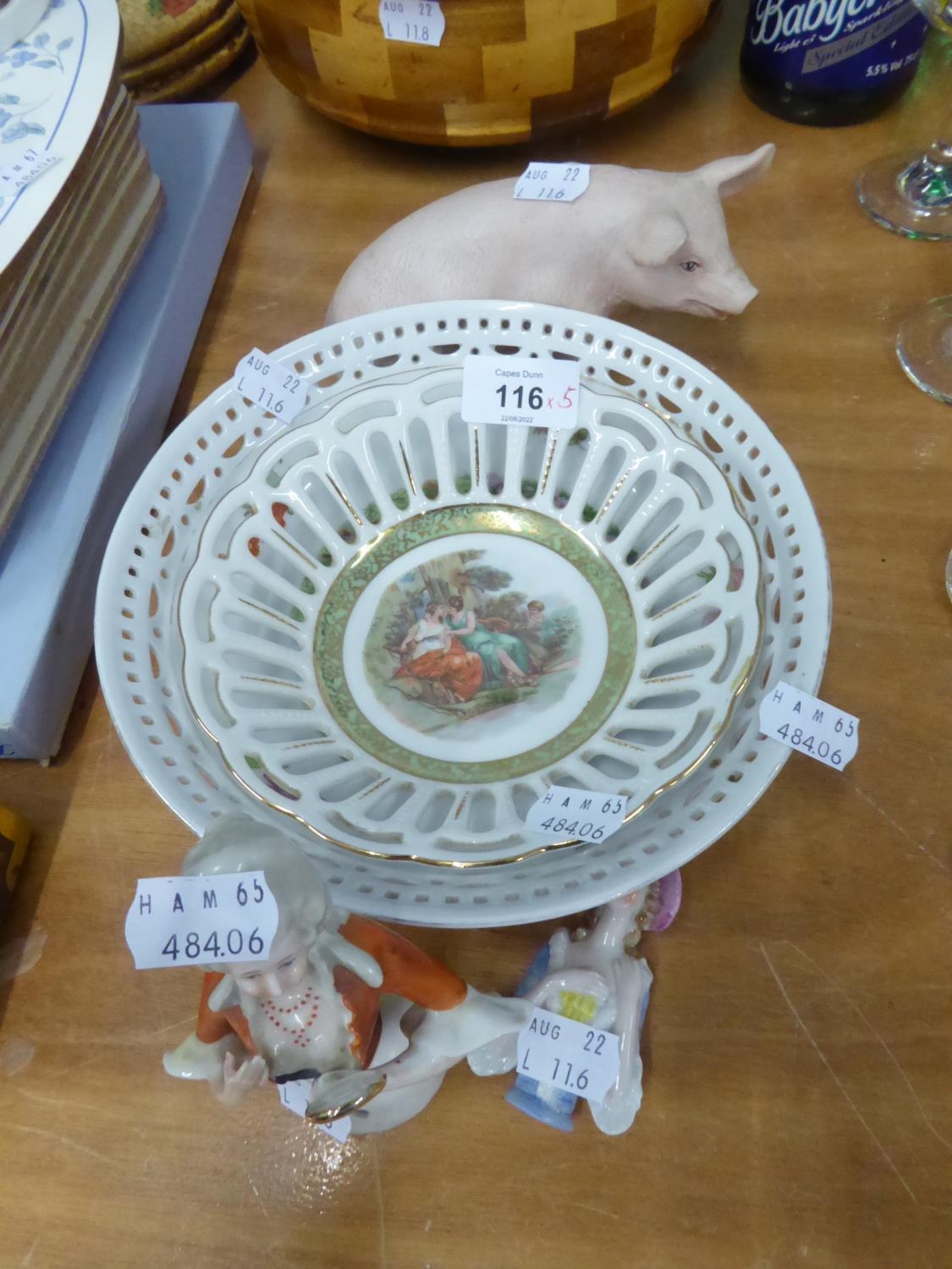 TWO CHINA PIN CUSHION HALF FIGURES; A TINTED BISQUE MODEL OF A PIG AND TWO CHINA RIBBON PLATES (5)