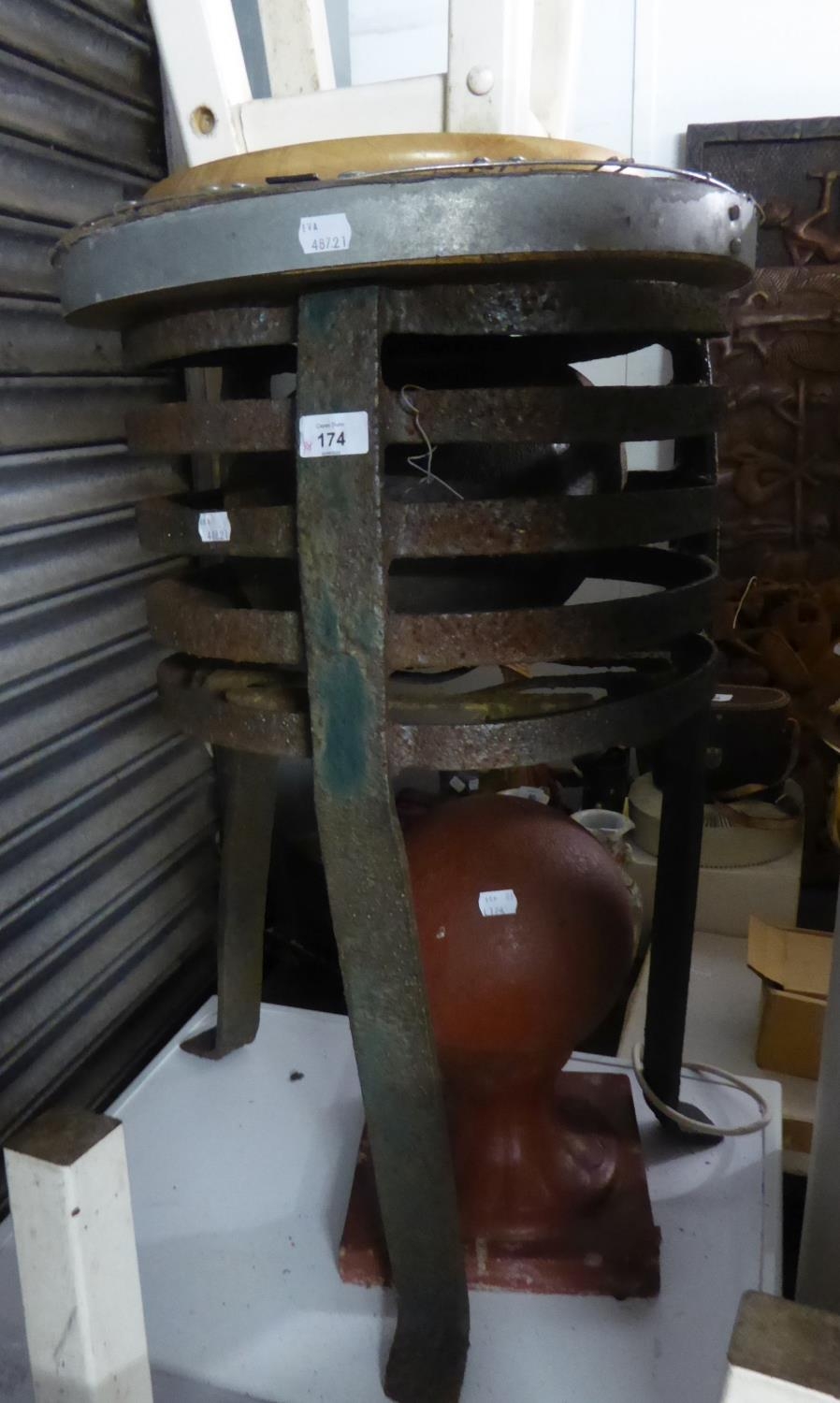 AN OLD WROUGHT IRON BRAZIER; A CAST IRON POT; A CROWN TOP CHIMNEY POT AND A TERRACOTTA PAINTED