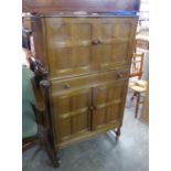 CIRCA 1960S CARVED LIGHT OAK COCKTAIL CABINET WITH FOUR PANE PATTERN DOORS AND MID-SECTION FULL-