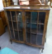 A MAHOGANY DWARF DISPLAY CABINET, ENCLOSED TWO BOW FRONTED DOORS, GADROON CARVED BORDER, ON FOUR