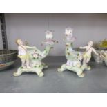 PAIR OF CONTINENTAL PORCELAIN FIGURAL BON BON DISHES WITH CANDLE HOLDERS IN THE ROCOCO TASTE, 7 ¼”