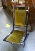 LATE 19TH CENTURY EBONISED WOOD FOLDING COACHING CHAIR, WITH BRASS NAILED GREEN PLUSH PADDED BACK