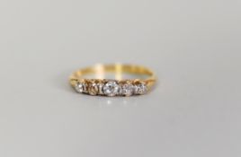 GOLD COLOURED METAL RING, set with five old cut diamonds graduating from the centre, 2.6gms,