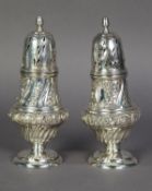 PAIR OF LATE VICTORIAN SILVER SUGAR CASTORS of GEORGIAN DESIGN, the ogee baluster bodies chased with