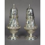 PAIR OF LATE VICTORIAN SILVER SUGAR CASTORS of GEORGIAN DESIGN, the ogee baluster bodies chased with