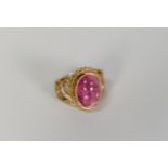9ct GOLD DRESS RING collect set with a cabochon oval amethyst, pierced scroll shoulders, 7.4 gms,