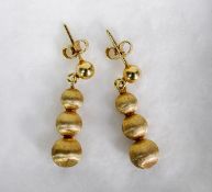 PAIR OF 9ct GOLD DROP EARRINGS of graduated triple ball pattern with brushed finish, 1 1/4in (3cm)