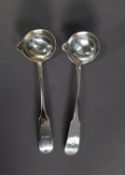 MATCHED PAIR OF GEORGE III IRISH SILVER FIDDLE PATTERN CRESTED SAUCE LADLES with pouring lips by