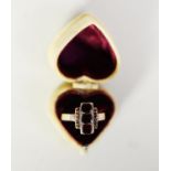 VICTORIAN GOLD COLOURED METAL RING, the top cross set with three garnets, cross set with a row of