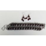 SILVER TRIPLE ROW CHAIN BRACELET with two rows each of 14 cup set cabochon oval dark red stones, 8in