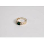 14ct GOLD RING with centre round dark green emerald, the shoulder each with a triangular setting