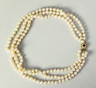 TRIPLE STRAND NECKLACE OF UNIFORM CULTURED PEARLS with 9ct gold, garnet and pearl cluster clasp,