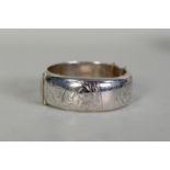 SILVER HINGE-OPENING BROAD BANGLE with foliate engraved top, Chester 1958