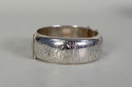 SILVER HINGE-OPENING BROAD BANGLE with foliate engraved top, Chester 1958