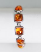 STERLING SILVER AND AMBER BRACELET comprising 10 square links, each collet set with a cabochon