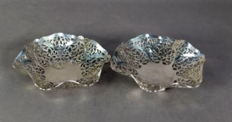 NEAR PAIR OF PIERCED SILVER DISHES, each of shallow, shaped circular form with foliate scroll