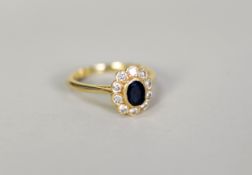 18ct GOLD, SAPPHIRE AND DIAMOND CLUSTER RING, with collet set centre oval dark blue sapphire and
