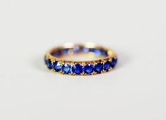 CONTINENTAL GOLD COLOURED METAL ETERNITY RING, set with 20 round cornflower blue sapphires, 2.3 gms,