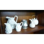A LARGE PORTMERION PARIAN FIGURE EMBOSSED JUG, A MATCHING SMALLER JUG, A SIMILAR SMALL JUG, A