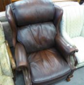 A BROWN HIDE WINGED RECLINING EASY ARMCHAIR