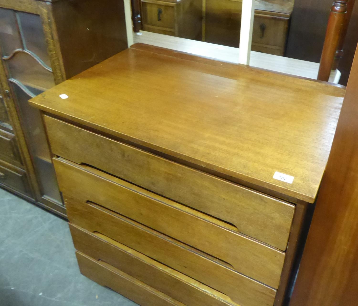 A TEAK CHEST OF FIVE LONG DRAWERS AND AN OBLONG COFFEE TABLE