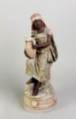 EARLY 20th CENTURY TINTED BISQUE FIGURE OF A NUBIAN GIRL holding a two-handled vase resting on her