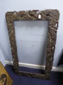 LATE NINETEENTH CENTURY JAPANESE CARVED AND PIERCED EBONISED WOOD BROAD PICTURE FRAME, relief carved