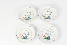 FOUR 20th CENTURY ORIENTAL PORCELAIN SAUCERS with shaped rims, each polychrome enamelled with a bird