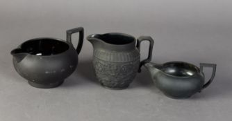 TWO NINETEENTH CENTURY WEDGWOOD BLACK BASALT POTTERY CREAM JUGS, one of squat form, the other