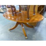 A YEW WOOD REGENCY STYLE OVAL LOW CENTRE TABLE, WITH EBONY STRING INLAY, CROSSBANDED BORDER, ON