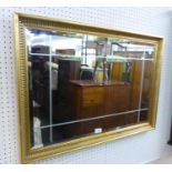 RECTANGULAR BEVELLED EDGE WALL MIRROR, WITH CUT-LINE DECORATION, IN FLUTED CAVETTO GILT FRAME, 1'11"