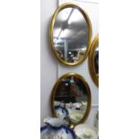 A PAIR OF GILT FRAMED OVAL WALL MIRRORS, 26” X 18 ½”