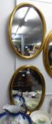 A PAIR OF GILT FRAMED OVAL WALL MIRRORS, 26” X 18 ½”
