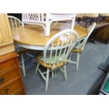 A CIRCULAR KITCHEN DINING TABLE, WITH LIGHT OAK TOP EXTENDING WITH ONE LOOSE LEAF, ON WHITE