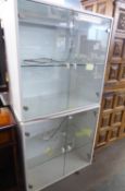 A WHITE ENAMELLED WOOD TWO TIER STACKING DISPLAY CABINET WITH HINGED PLATE GLASS DOORS AND A PLATE