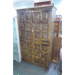 A CONTINENTAL CARVED SOFTWOOD COCKTAIL CABINET, ENCLOSED BY TWO PAIRS OF DOORS, EACH DOOR WITH SIX