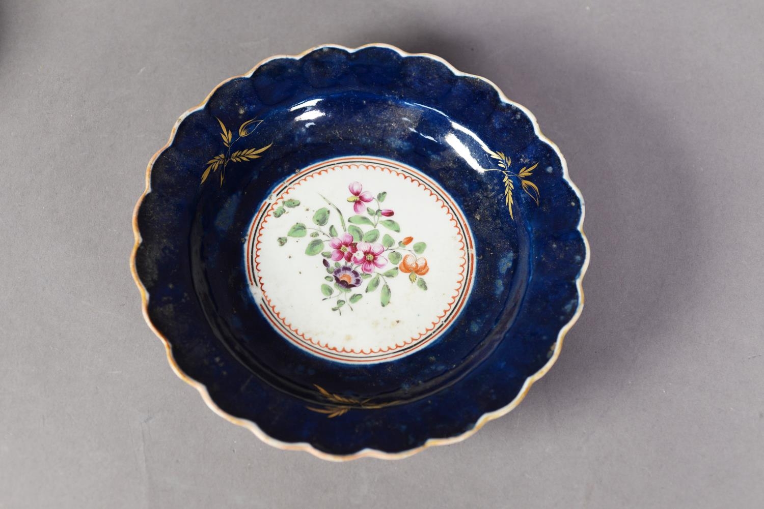 EIGHTEENTH CENTURY WORCESTER PORCELAIN SCALLOPED PLATE, the centre enamelled with a floral spray