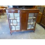 A MAHOGANY BOW FRONTED DISPLAY CABINET WITH LEDGE BACK, TWO GLAZED DOORS FLANKING A CENTRE PANEL,