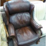 A BROWN HIDE WINGED RECLINING EASY ARMCHAIR