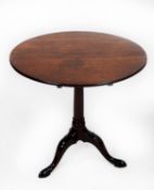 GEORGIAN MAHOGANY TILT TOP OCCASIONAL TABLE, the circular top set above a gun barrel turned