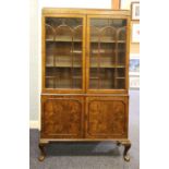 EARLY TWENTIETH CENTURY FIGURED WALNUT DISPLAY CABINET, the moulded oblong top above a pair of