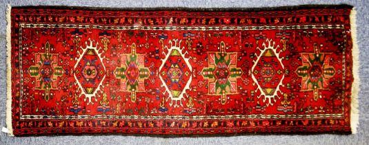 EASTERN RUNNER with row of seven large medallions, on a crimson field decorated with flowers,